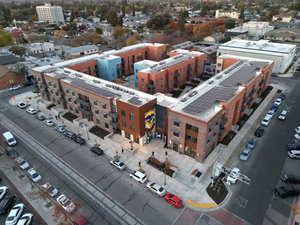 An aerial view of a building with cars parked on the side.