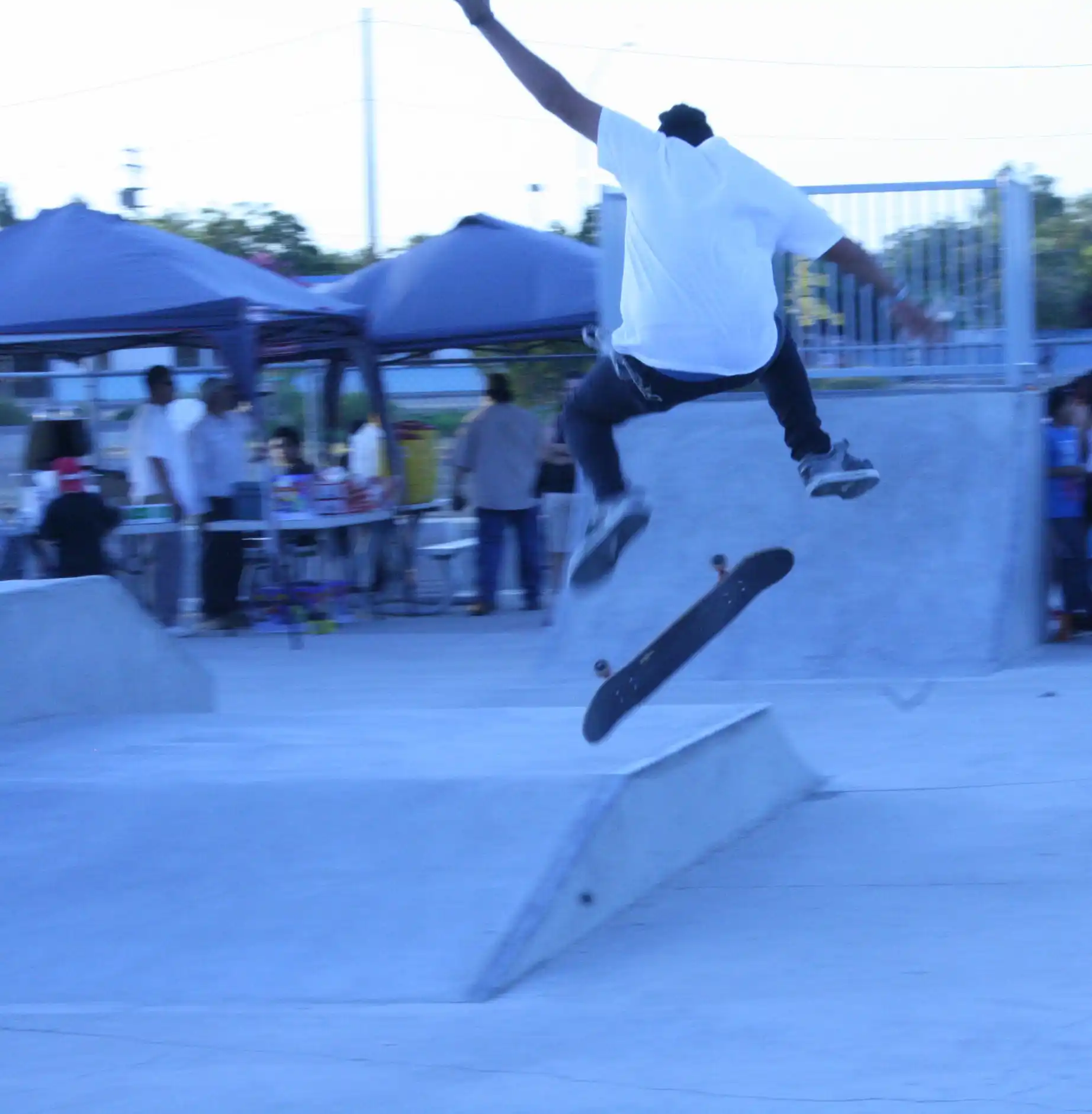 A man on a skateboard doing tricks in the air.