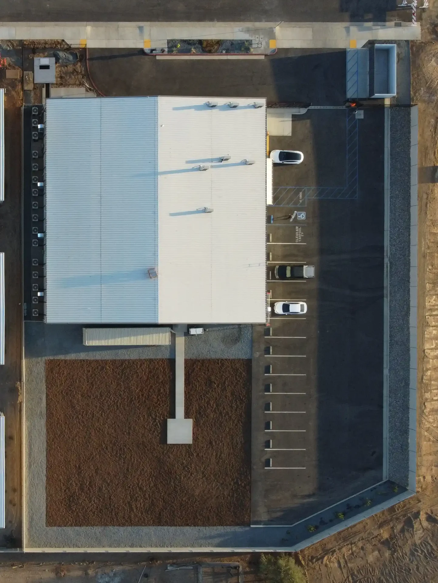 A aerial view of a building with cars parked on the side.