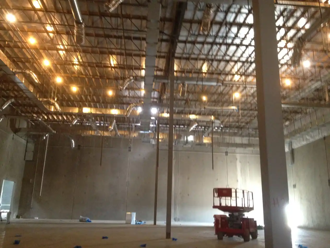 A large warehouse with lights on the ceiling.