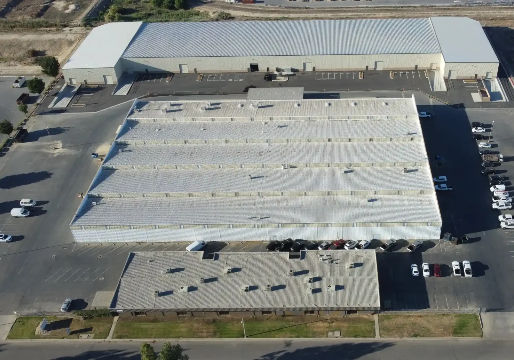 A large warehouse with many cars parked in it.